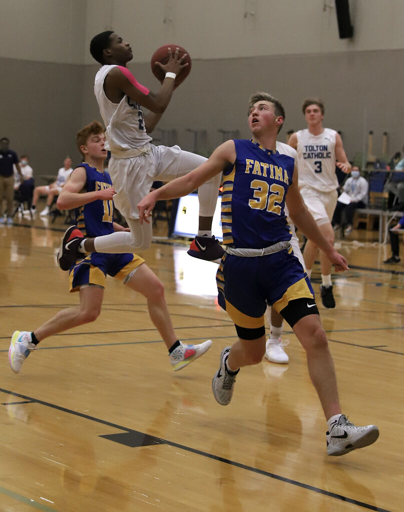 Tre McCluney jumps for a basket past Fatima's Trey Herzing